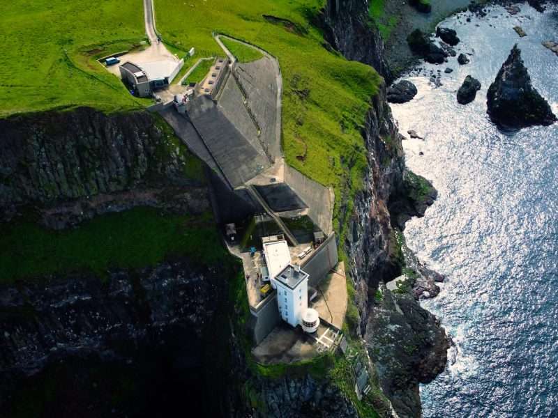 aerial drone view of Rathlin lighthouse with dramatic cliffs either side