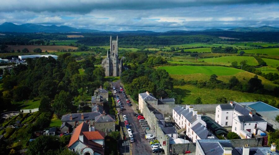 aerial drone view of a cathedral in Downpatrick with mountains and fields on the horizon