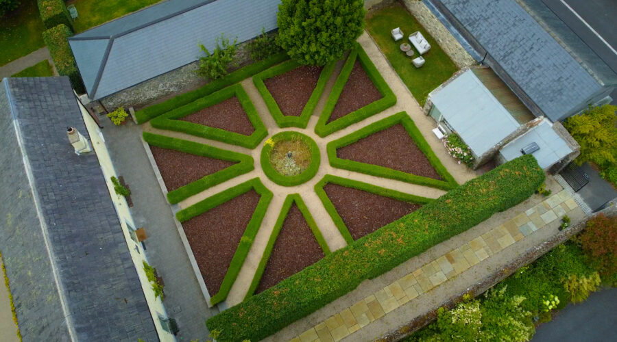 aerial drone shot of a topiary garden in a courtyard