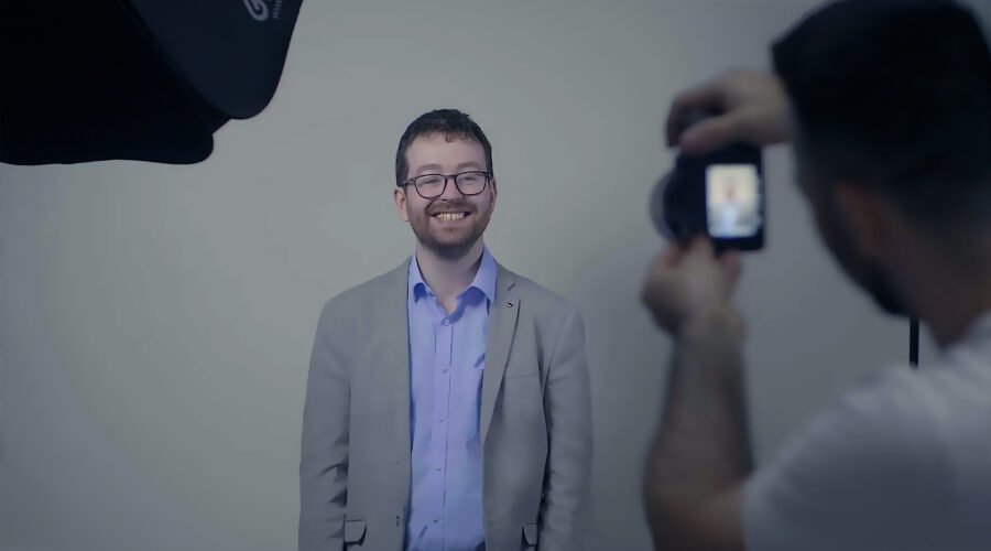 smiling man having his headshot photo taken