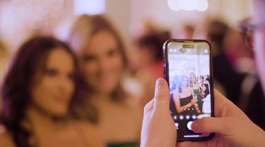 iphone taking a photo of two posing women in soft focus