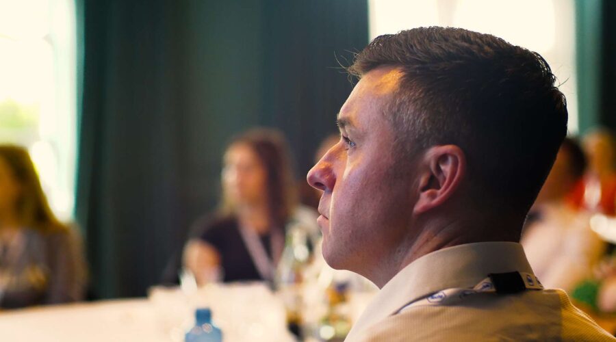 man listening at a business conference