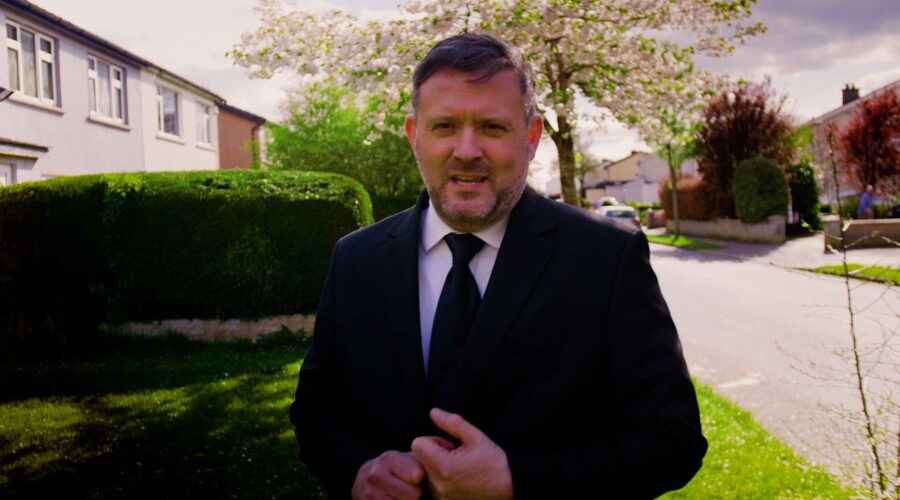 man walking and speaking to camera