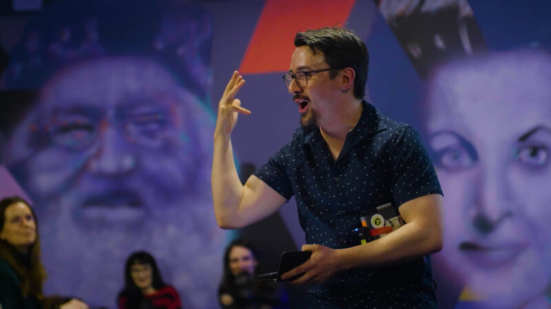 man at a live event holding up his hand and yelling