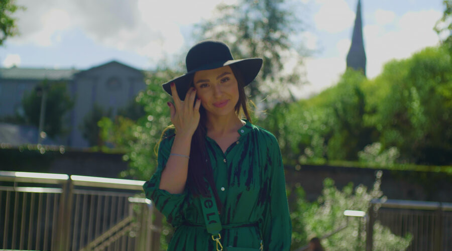 fashion model wearing a green dress and wide rimmed hat