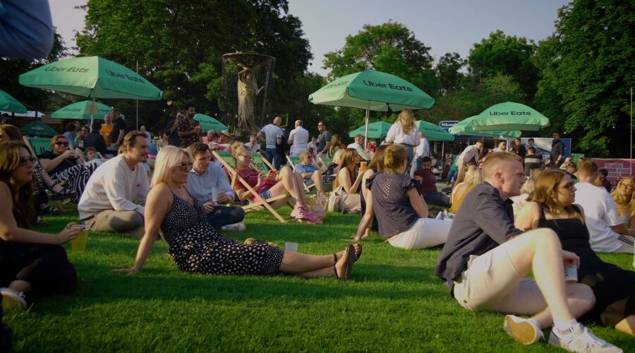 people-sitting-on-grass-with-parasols