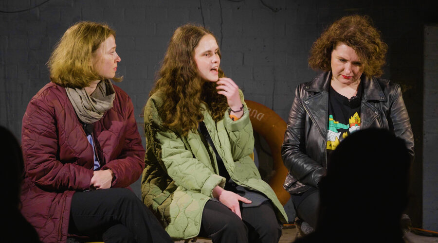 three women talking on stage at a live event