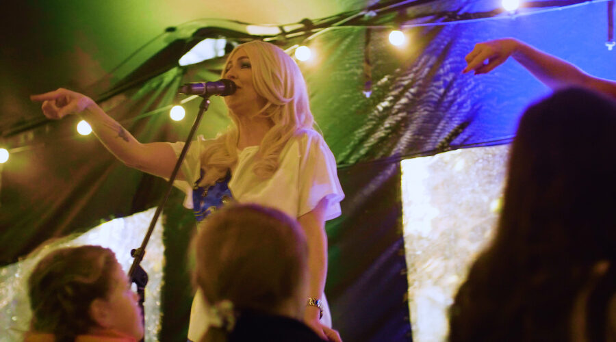 woman singing on stage pointing at the crowd